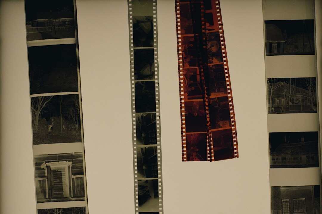 Stack of vintage advertising film reels and printed posters on a light table